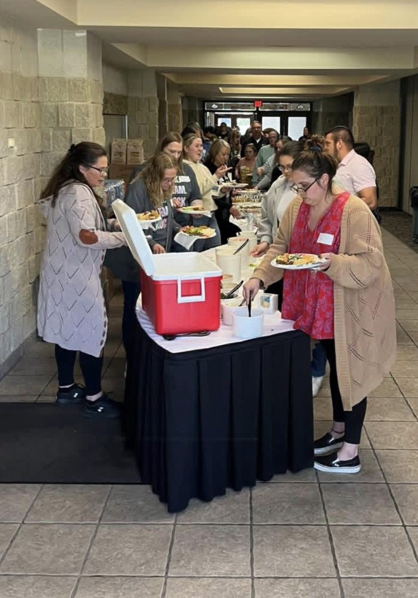 Guests serving themselves from a Diaz Grocery Catering buffet line at an event